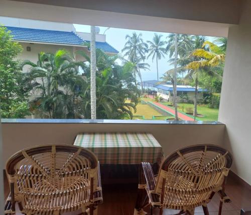 a room with a table and two chairs and a window at Seashore Beach Resort Varkala in Varkala