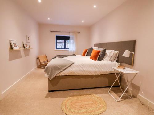a bedroom with a large bed and a table at Grange Barn in Shrewsbury