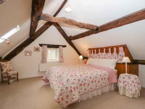 a bedroom with a bed in a attic at Anvil Cottage in Blakeney
