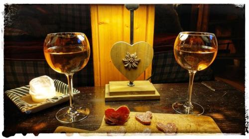 Formidable Chalet Authentique sur la Place d'Auron في أورو: كأسين من النبيذ يجلسون على طاولة مع الطعام