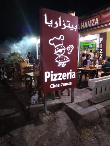 a sign in front of a restaurant at night at Venus house15 in Raoued