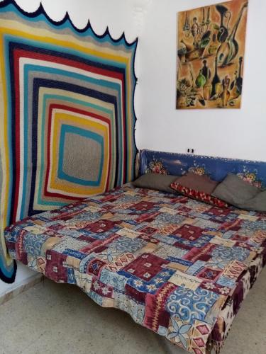 ein Schlafzimmer mit einem Bett mit einer bunten Decke in der Unterkunft Venus house15 in Raoued