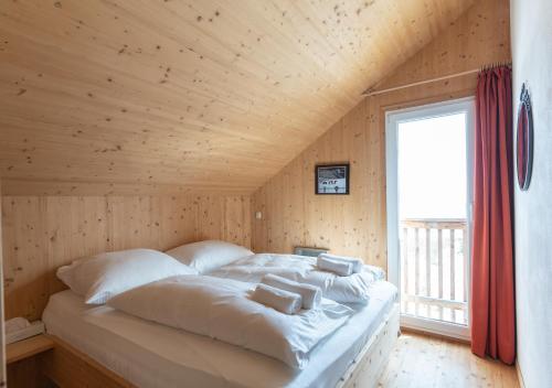 Cama en habitación con techo de madera en 1A Chalet Nest - Grillen und Wandern, Panorama Sauna! en Klippitztorl