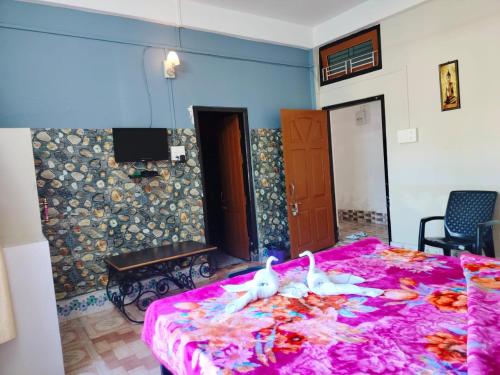 Un dormitorio con una cama rosa con dos cisnes. en Kareng guest house, en Kāziranga