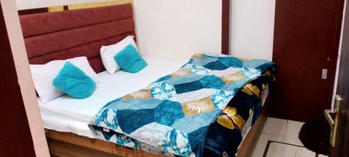 Bett mit blauen Kissen auf einem Zimmer in der Unterkunft Arora classic guest house in Amritsar