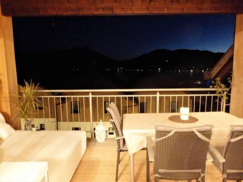 a table and chairs on a balcony at night at Apartment With Amazing Lake- and Mountain View in Ober Feuchten
