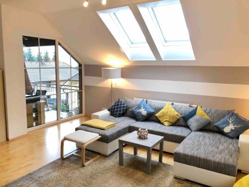 a living room with a couch and a skylight at Apartment With Amazing Lake- and Mountain View in Ober Feuchten