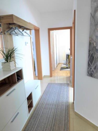 a living room with a white dresser and a hallway at Apartment With Amazing Lake- and Mountain View in Ober Feuchten