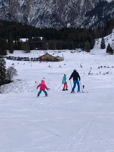 a group of people skiing down a snow covered slope at Apartment With Amazing Lake- and Mountain View in Ober Feuchten