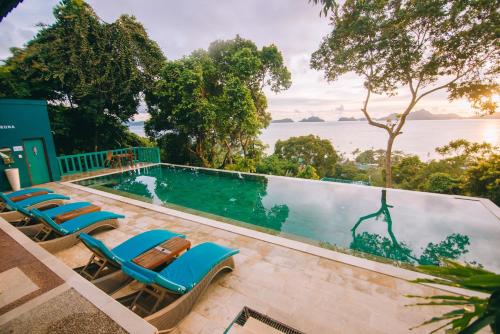 a pool with lounge chairs and a view of the water at Unique Stays at Karuna El Nido - The Dome in El Nido