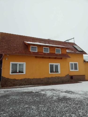 ein gelbes Haus mit drei Fenstern auf einer Straße in der Unterkunft Narcise kulcsoshaz in Joseni