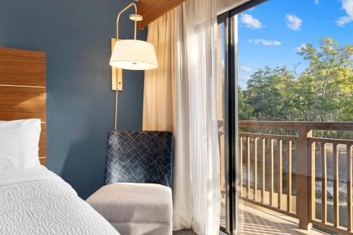 a bedroom with a bed and a balcony with a window at Holiday Inn Express Hilton Head Island by IHG in Hilton Head Island