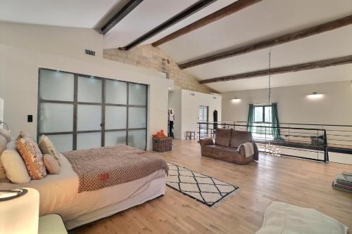 une chambre avec un lit et un canapé dans une pièce dans l'établissement Mas Volver Camargue, à Arles