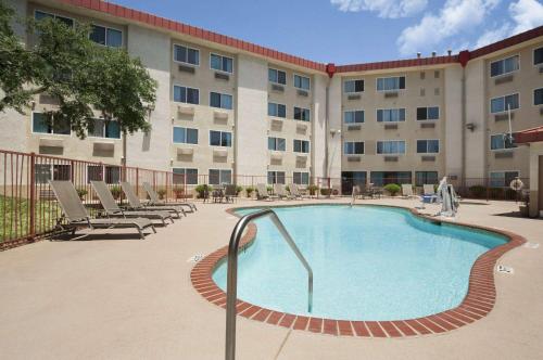 a large building with a swimming pool in front of a building at Super 8 by Wyndham Austin North/University Area in Austin