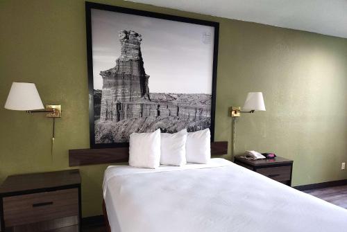 a hotel room with a bed with a picture on the wall at Super 8 by Wyndham Austin North/University Area in Austin