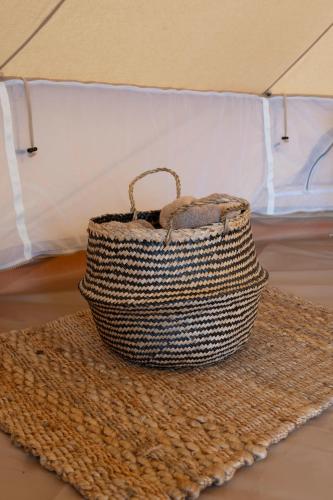 a wicker basket sitting on top of a rug at Pura Eco Retreat, Jebel Hafit Desert Park in Al Ain