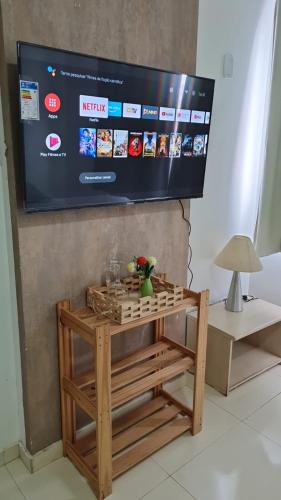 a television hanging on a wall with a wooden table at PRIME HOSPEDAGENS - RESIDÊNCIAL BELLÁGIO in São Luís