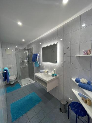 a bathroom with a sink and a shower and a toilet at Apartmenthaus Simmer in Obertraun