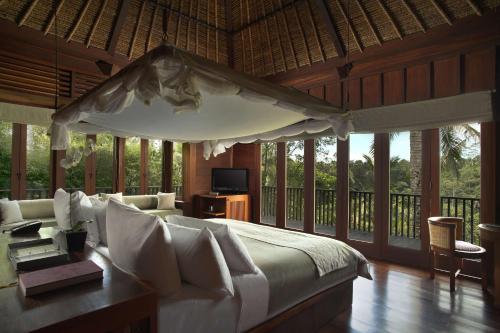 een slaapkamer met een bed en een televisie. bij Alila Ubud in Ubud