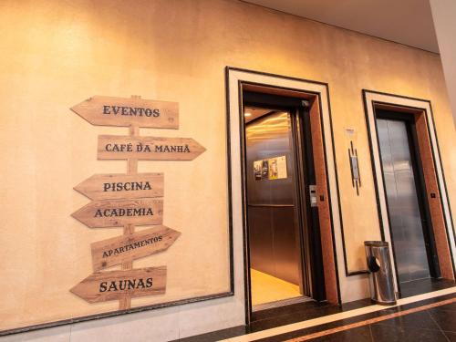 a sign with arrows pointing to different places in a building at ibis Styles Presidente Prudente Portal D'Oeste in Presidente Prudente