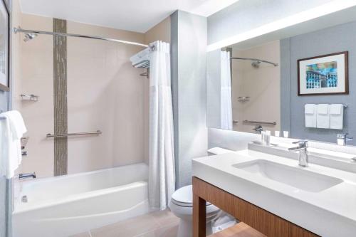 a bathroom with a sink and a tub and a toilet at Hyatt Place Fort Worth-Alliance Town Center in Fort Worth