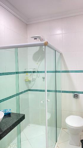 a bathroom with a glass shower and a toilet at Casa de 2 QUARTOS COM PISCINA in Balneário Camboriú
