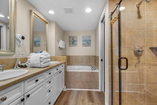 ein Badezimmer mit Dusche, Waschbecken und Badewanne in der Unterkunft Portofino Island Resort 1-1306 in Pensacola Beach