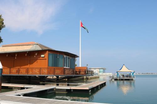 a building on a dock on a body of water at Palma Beach Resort & Spa in Umm Al Quwain