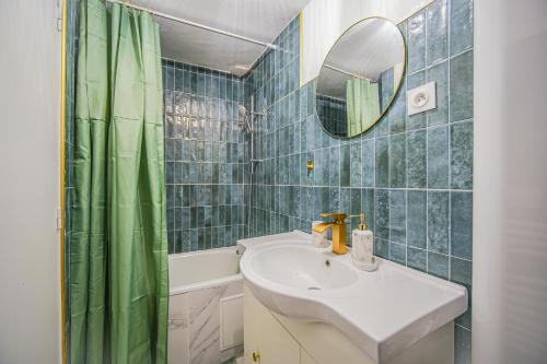een badkamer met een wastafel en een groen douchegordijn bij Le 2en1 Roissy CDG in Longperrier