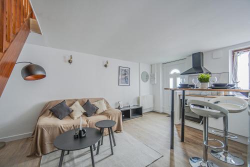 un petit salon avec un canapé et une cuisine dans l'établissement Le 2en1 Roissy CDG, à Longperrier