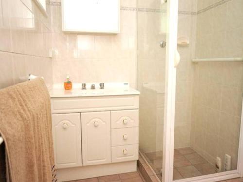 a white bathroom with a sink and a shower at It's on Walnut in Mildura