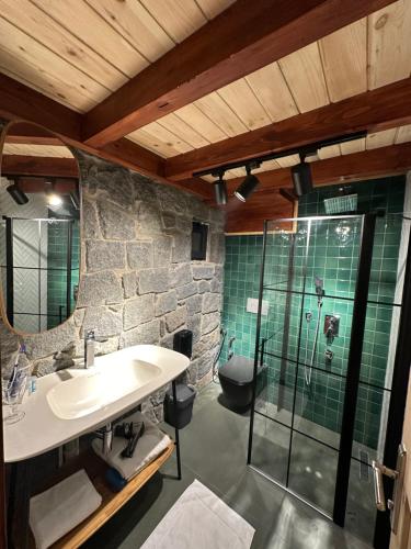 a bathroom with a sink and a glass shower at Özen Villa Apart in Uzungol