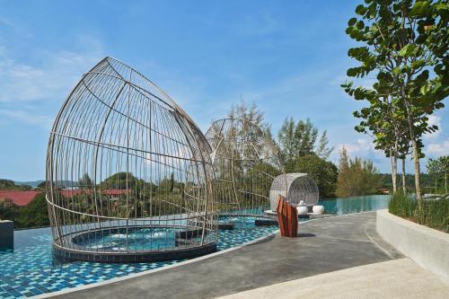 a set of three metal structures around a swimming pool at Aloft Langkawi Pantai Tengah in Pantai Cenang