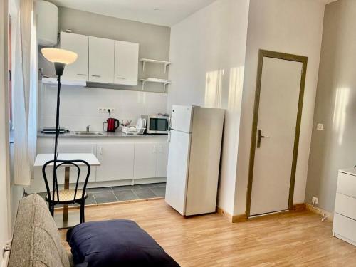 a kitchen with a refrigerator and a table with a chair at Studio comfortable charleroi in Charleroi