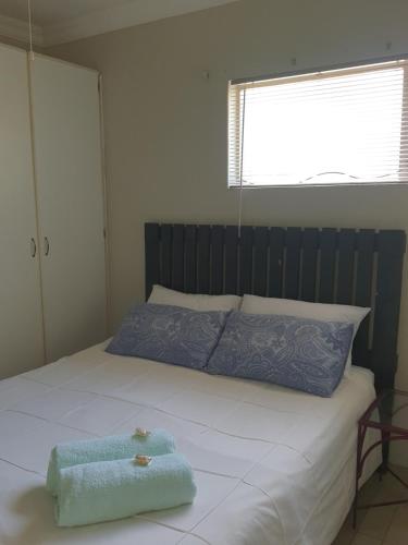 a bed with a blue towel on top of it at Jean Michael Self-catering apartment for stay overs in Pretoria