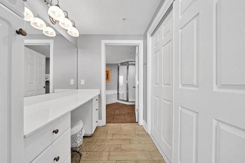 a white bathroom with white cabinets and a hallway at Majestic Beach Towers 2-1701 in Panama City Beach