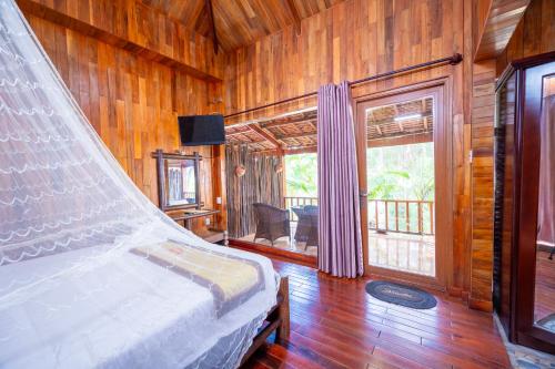 1 dormitorio con 1 cama en una habitación con paredes de madera en Chez Carole Beach Resort Phu Quoc en Phu Quoc