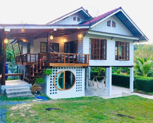 a house with a porch and a balcony at Baan Sangchan in Ko Kood