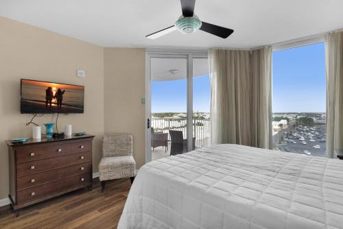 ein Schlafzimmer mit einem Bett und eine Kommode mit einem Fenster in der Unterkunft Palms Resort #1814 Jr. 2BR in Destin