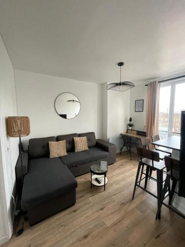 un salon avec un canapé et une table dans l'établissement Charmant appartement proche Paris et Stade de France !, à Saint-Denis