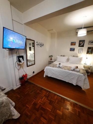 a bedroom with a large bed and a flat screen tv at Vivi la mejor experiencia en el corazon de BA !!!! in Buenos Aires