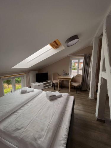 a bedroom with a large white bed and a table at Villa Seebach in Boltenhagen