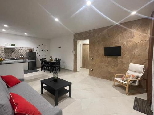 a living room with a couch and a table and a kitchen at La Palma del Nonno in Mazara del Vallo