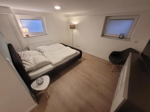 a small bedroom with a bed and a chair at Zimmer im Souterrain mit eigenem Bad in Celle