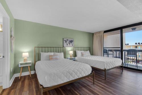 a bedroom with two beds and a balcony at SunDestin 416 in Destin