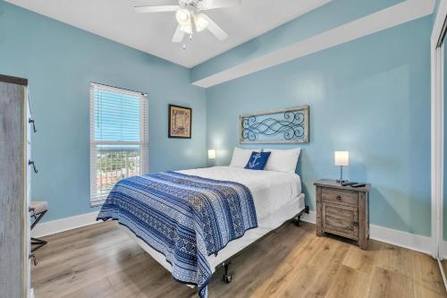 um quarto com paredes azuis, uma cama e uma janela em Majestic Beach Towers 1-1710 em Panama City Beach