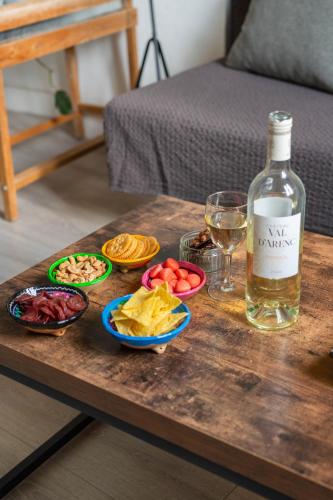 - une table avec une bouteille de vin et des assiettes de nourriture dans l'établissement STUDIO VIEUX-PORT VUE BASILIQUE NOTRE-DAME, à Marseille