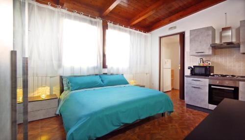 a bedroom with a blue bed and a kitchen at Sea breeze Villa - Luna apartment in Bari Palese