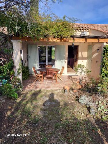 un patio avec une table et des chaises devant une maison dans l'établissement Villa les Gabians, à Saint-Laurent-du-Var