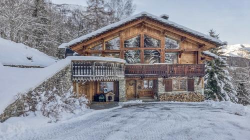 une cabane en rondins dans la neige avec une allée dans l'établissement Chalet Castor, aux Houches